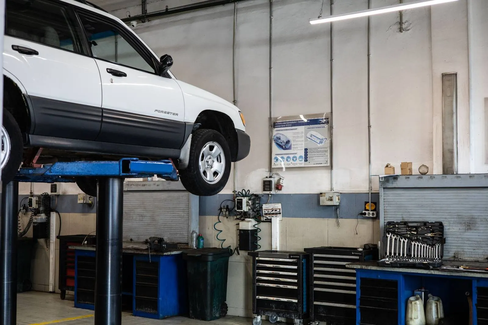 A car on a lift in an auto repair shop service bay
